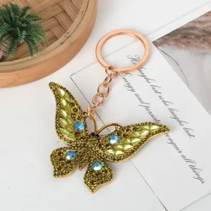 Detailed view of a golden butterfly keychain encrusted with green and blue rhinestones
