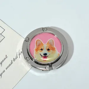 Macro view of portable foldable metal bag hook with a cute corgi dog illustration