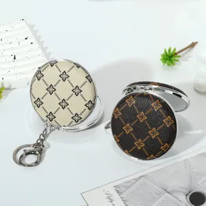 Detail view of mini folding makeup mirrors with vintage patterns and metal keychains
