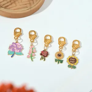 Detailed view of five colorful floral enamel charms with gold-tone heart-pattern lobster clasps