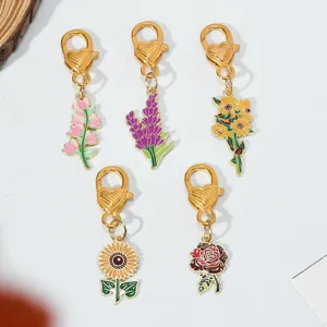 Detail view of five colorful floral enamel charms with heart-shaped gold clasps