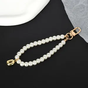 Elegant white pearl keychain featuring a gold letter pendant and durable lobster clasp