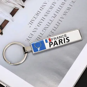 Primo piano di un portachiavi in metallo rettangolare con design targa Parigi e Francia