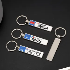 Vista dettagliata di portachiavi rettangolari in metallo con motivi Canada, Francia e Croazia