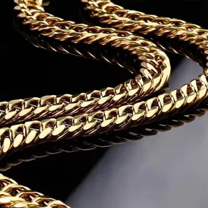 Close-up detail of a thick 18K gold plated Cuban link necklace with high metallic shine.