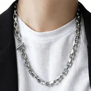 Close-up of a high-polish chunky stainless steel chain necklace with toggle clasp on model