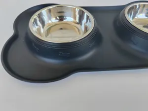 Silicone double pet bowl detail showing stainless steel bowls and black mat with bone patterns.