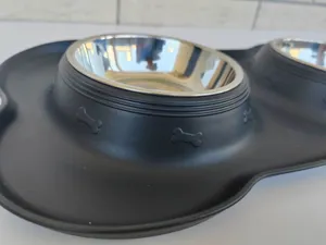 Stainless steel pet double bowl with black silicone mat detail showing embossed bone pattern design