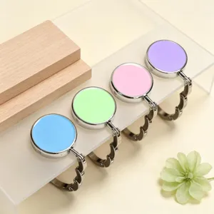 Close-up view of four colorful foldable portable purse hangers for desk edges and office