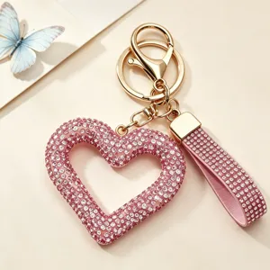 Close-up of a pink heart keychain with sparkling rhinestones and gold hardware
