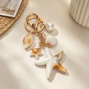 Close-up of ocean-themed keychain with starfish, seashell, conch and pearl charms