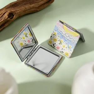 Detail view of oil painting style compact makeup mirror with double-sided folding design