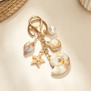 Close-up detail of a gold keychain featuring realistic shell conch and starfish charms.