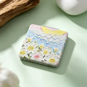 Close-up of the artistic oil painting pattern on a portable folding square makeup mirror.