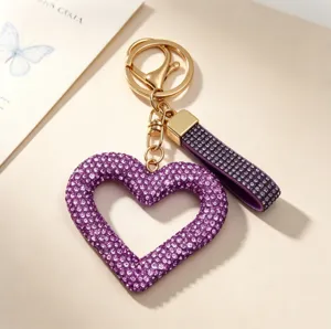 Close-up of a sparkling purple heart-shaped rhinestone keychain with gold clasp