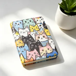 Portable folding makeup mirror with cute colorful cartoon cat pattern on white desk.