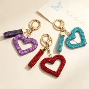Close-up of hollow heart keychains in red, purple, and blue with sparkling rhinestones