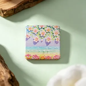 Detail view of folding makeup mirror featuring cherry blossom and beach oil painting