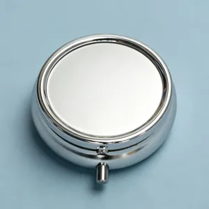 High-quality macro detail of a round silver metal pill box with a polished finish