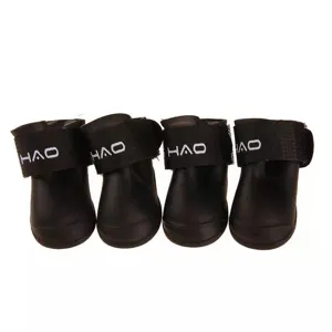 Detail view of black silicone waterproof pet dog rain boots, set of four shoes for small dogs.