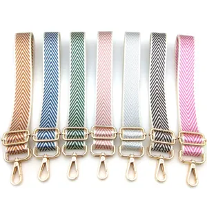 Detalle de correa ajustable para bolso con diseño de espiga en varios colores y ganchos