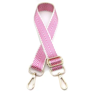 Primer plano de una correa de bolso ajustable con patrón de chevrons rosa y blanco