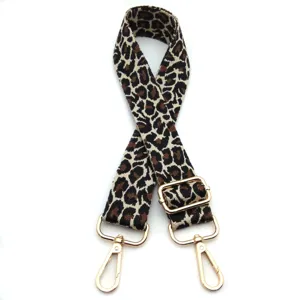 Detailed view of the leopard print bag strap with adjustable gold-toned hardware buckle