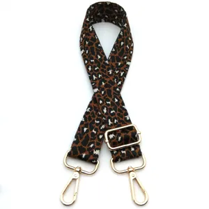 Detailed view of an adjustable leopard print bag strap featuring gold-tone swivel hooks