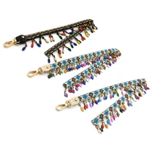 Macro view of bohemian ethnic embroidered straps with colorful beaded tassels and gold hooks