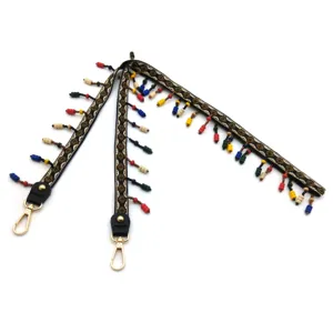 Detail of ethnic style shoulder strap featuring colorful beads and gold metal clasps