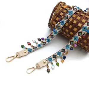 Close-up of ethnic style embroidered strap with colorful beads and heart-shaped tassels