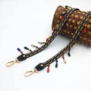 Detail view of Bohemian beaded shoulder strap with ethnic embroidery and gold clips
