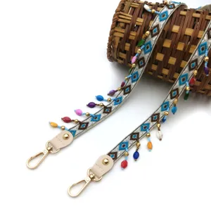 Detail of an ethnic style shoulder strap with colorful beads and gold clips.