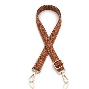 Detail of orange and green chevron woven strap with adjustable gold buckle and hooks