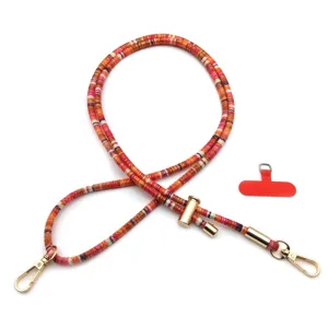 Close-up of colorful woven phone lanyard with gold metal hooks and red patch