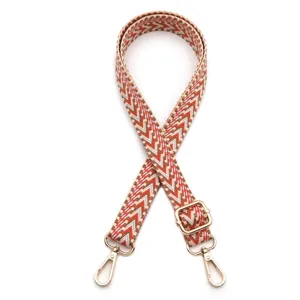Detailed view of the woven chevron pattern shoulder strap with gold-toned metal adjustment buckle