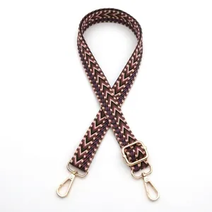 Detailed view of adjustable woven bag strap with purple chevron pattern and gold clips