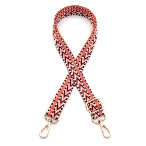 Adjustable shoulder strap featuring orange chevron pattern and polished gold metal hooks