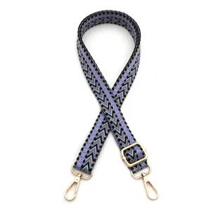 Detail of woven bag strap with purple and green chevron pattern and gold hardware
