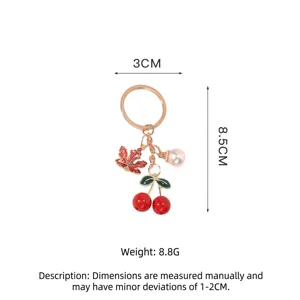 Close-up of cherry and maple leaf keychain with pearl and size dimensions