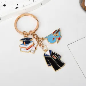Detail view of graduation keychain featuring bachelor gown and book stack pendants