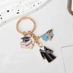 Detailed view of graduation-themed keychain charms with bachelor gown and books