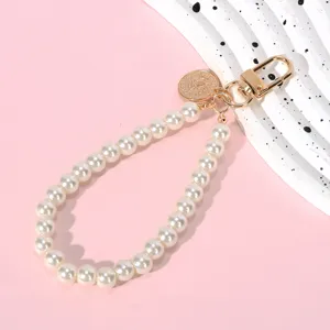 Close-up of elegant cream pearl chain with golden clasp for bags and phone DIY