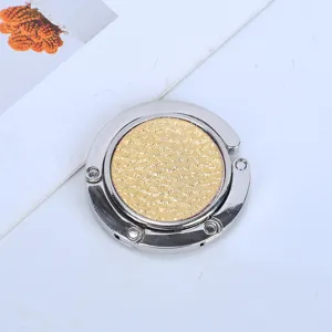 Compact folding metal bag hanger for desks featuring a golden glitter texture
