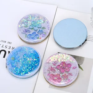 Top view of portable quicksand folding makeup mirrors with colorful glitter flower designs