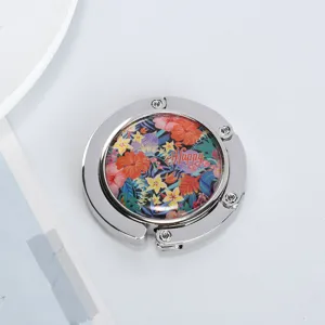 Detailed view of portable foldable table bag hook featuring a colorful floral Happy design