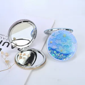 Detailed view of the blue glitter quicksand folding mirror with a shiny metal frame