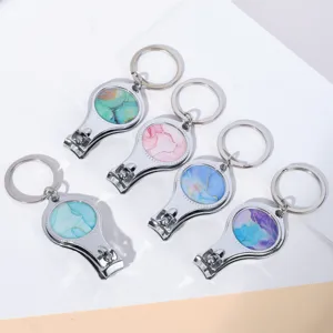 Detailweergave van nagelknipper-sleutelhangers met kleurrijk marmerpatroon in diverse tinten