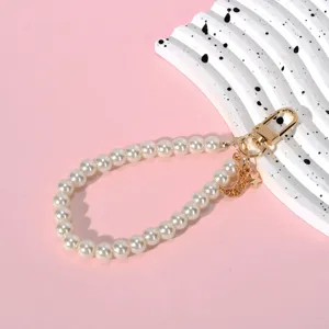 Detail of pearl lanyard with golden moon and star charms and a sturdy lobster clasp.