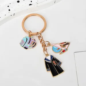 Macro view of graduation gown, school bag and academic charms on a gold-plated keychain.